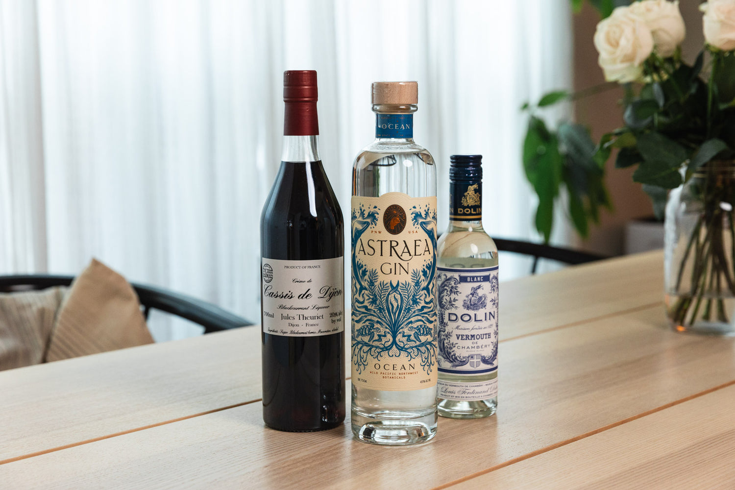 Three bottles of alcohol on a table with a blurred background