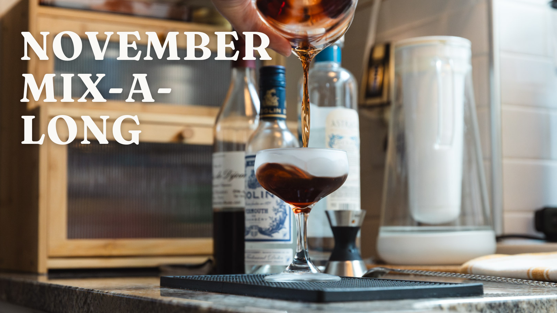 Cocktail being poured into a glass with bottles and bar tools in the background, featuring 'November Mix-a-Long' text.